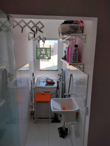 a small bathroom with a sink and a mirror at Cozy Home Arembepe Beach in Camaçari