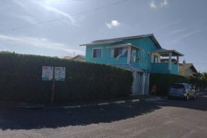 a blue house with a car parked in front of it at Cozy Home Arembepe Beach in Camaçari