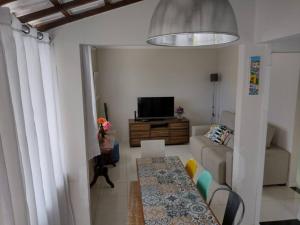 a living room with a couch and a tv at Cozy Home Arembepe Beach in Camaçari