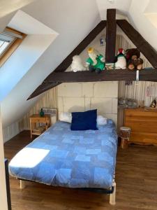 a bedroom with a blue bed in a attic at La Maison du Donjon - Gites de 8 personnes, parking privé avec jardin terrasse in Loches