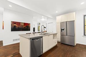 a kitchen with white cabinets and a stainless steel refrigerator at Tranquil Haven Retreat in Detroit
