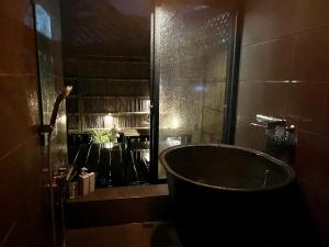 uma banheira na casa de banho com uma janela em GOEMON The Last Japan 