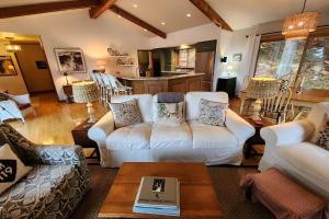 un soggiorno con divani bianchi e tavolo di Birchwood Lakeview a Harbor Springs