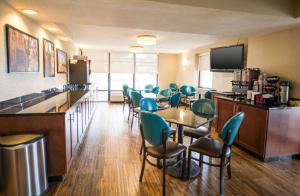 una sala de espera con sillas y mesas y un bar en Pear Tree Inn Cape Girardeau Medical Center, en Cape Girardeau