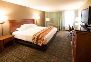 a hotel room with a bed and a flat screen tv at Pear Tree Inn Cape Girardeau Medical Center in Cape Girardeau