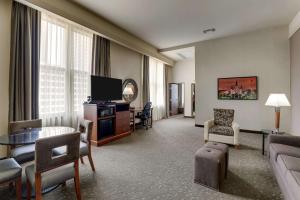 a living room with a couch and a television in a hotel room at Drury Plaza Hotel New Orleans in New Orleans
