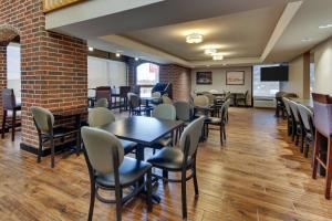 a dining room with tables and chairs and a brick wall at Drury Inn & Suites Poplar Bluff in Poplar Bluff