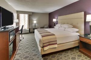 a hotel room with a large bed and a flat screen tv at Drury Inn & Suites Poplar Bluff in Poplar Bluff