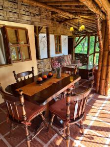 a dining room with a wooden table and chairs at Ecohotel Monteverde in La Vega