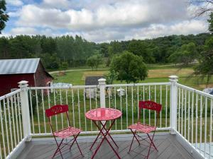 two pink chairs and a table on a porch at Bass Creek's Cozy Outback Country Retreat in Janesville