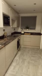 a kitchen with white cabinets and a counter top at Ribbleton Rendezvous in Preston in Preston