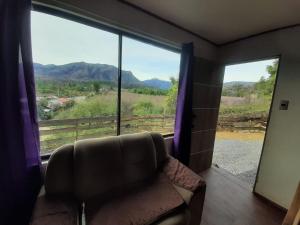 un soggiorno con divano e una grande finestra di Cabañas el castaño a El Torreón