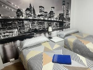 2 camas en un dormitorio con vistas al perfil urbano en Gijon center, en Gijón