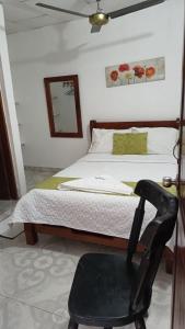 una camera con letto e sedia nera di Hotel Majestic Mompox a Mompós