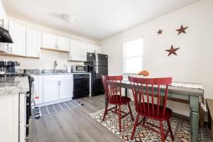 a kitchen with a table and two red chairs at Croquet - Fire Pit - Central Location in Bloomington