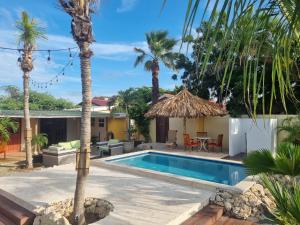 een villa met zwembad en palmbomen bij Aruba SeaScape Apartments in Palm-Eagle Beach