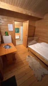 a room with a bed and a table in a cabin at Artur´s Eaterie and Holiday home in Viitna