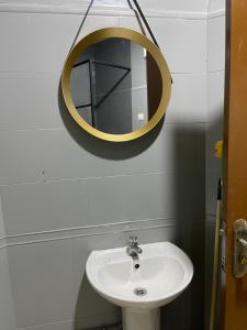 uma casa de banho com um lavatório e um espelho na parede em Appartement luve em Orã