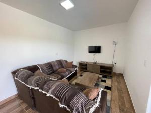 ein Wohnzimmer mit 2 Sofas und einem TV in der Unterkunft Chácara pôr do sol in Socorro