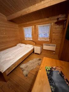 a bedroom with a bed in a log cabin at Artur´s Eaterie and Holiday home in Viitna