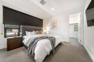 a bedroom with a large bed with a large headboard at Terra Haus - Renovated WiFi Glenelg in Glenelg