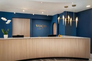 a lobby with blue walls and a voya sign on the wall at voco Vienna Prater, an IHG Hotel in Vienna