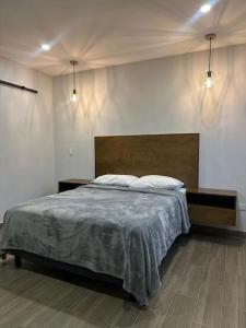 ロレトにあるDepa del Carmenのベッドルーム1室(ベッド1台、テーブル2台、照明2つ付)