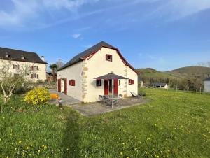 a white barn with red doors in a field at Parote txipia in Musculdy