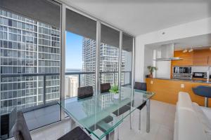 a dining room and kitchen with a glass table at *W ICON BRICKELL- LUXURY 2BR HIGHRISE CORNER CONDO** in Miami