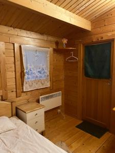 1 dormitorio con 1 cama en una habitación de madera en Artur´s Eaterie and Holiday home, en Viitna