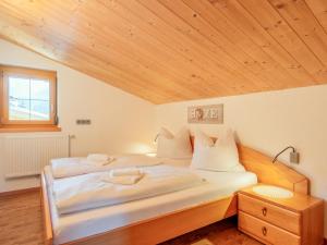 a bedroom with two beds and a wooden ceiling at Obinghof in Söll
