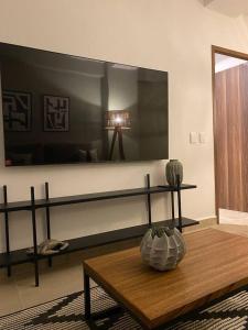 a living room with a table and a large mirror at Departamento nuevo con vista a la Piscina in Nuevo Vallarta 