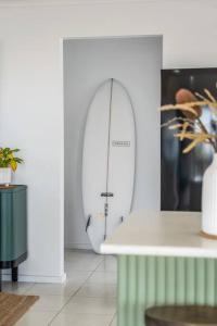 a white room with a surfboard in the corner at Soul Beach House - Beach Family WiFi in Christies Beach