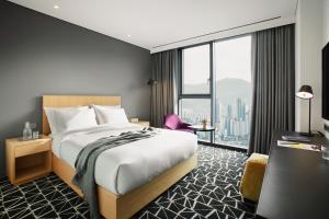 a hotel room with a bed and a large window at L7 Gangnam in Seoul