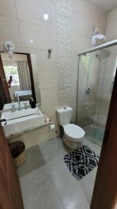 een badkamer met een toilet, een douche en een wastafel bij Recanto dos Sabiás - Chalés São Bonifácio SC in São Bonifácio