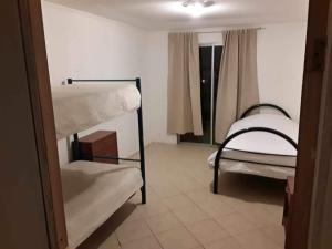 a room with two bunk beds and a window at Cabaña en Pica con Jacuzzi privado in Pica