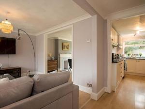 a living room with a couch and a kitchen at Large 4 Bed House near River Thames in Old Windsor