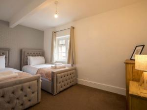 1 dormitorio con 2 camas y ventana en Large 4 Bed House near River Thames, en Old Windsor