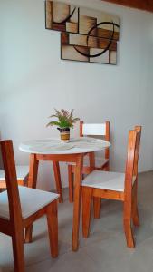 a table and two chairs with a potted plant on it at Hermoso Departamento En La Ciudad De Mendoza in Barraquero +4 photos