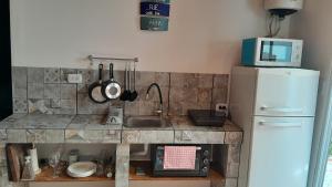 a small kitchen with a sink and a refrigerator at Hermoso Departamento En La Ciudad De Mendoza in Barraquero