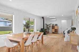 a dining room with a wooden table and white chairs at The Arches ~ Style, location and spacious living! in McLaren Vale