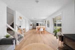sala de estar con escalera y mesa en The Arches ~ Style, location and spacious living! en McLaren Vale
