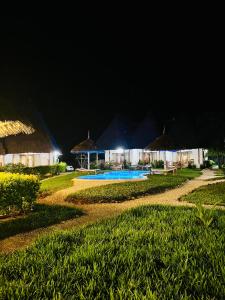 a resort with a swimming pool at night at MITI Beach Bungalows in Nungwi