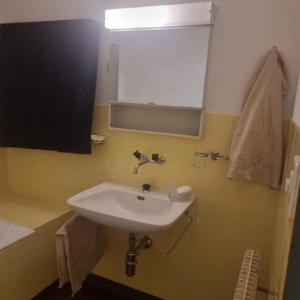 uma casa de banho com um lavatório branco e um espelho. em Queen Home em Lucerna