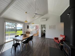 een keuken en een woonkamer met een tafel en stoelen bij Boomers Retreat, Alonnah, Bruny Island in Alonnah