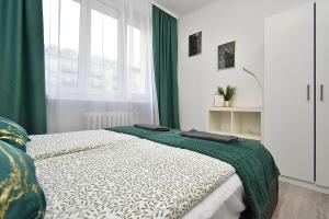 a bedroom with a bed with green curtains and a window at Rental Apartments Aleja Niepodległości in Warsaw +68 photos