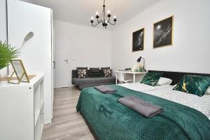 sypialnia z łóżkiem z zielonym kocem w obiekcie Rental Apartments Aleja Niepodległości w Warszawie