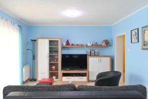 salon z kanapą i telewizorem w obiekcie Family-friendly apartments with swimming pools Opatija - 7916 w mieście Opatija
