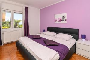 sypialnia z dużym łóżkiem i fioletowymi ścianami w obiekcie Family-friendly apartments with swimming pools Opatija - 7916 w mieście Opatija +16 zdjęć