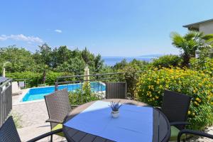 stół i krzesła oraz basen w obiekcie Family-friendly apartments with swimming pools Opatija - 7916 w mieście Opatija